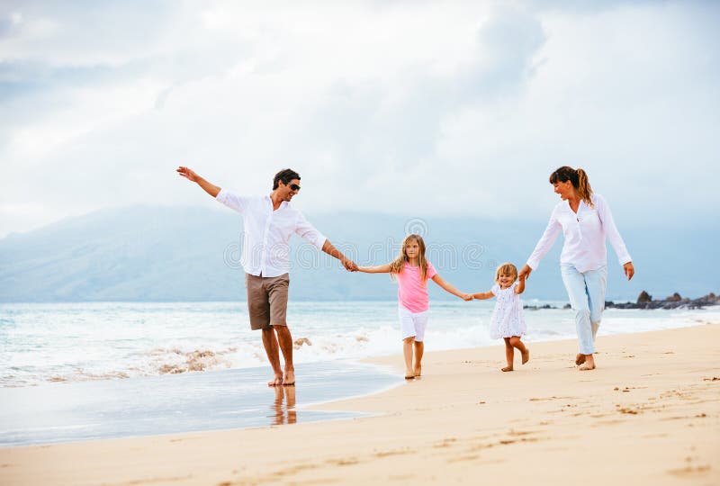 Happy young family walking on the beach