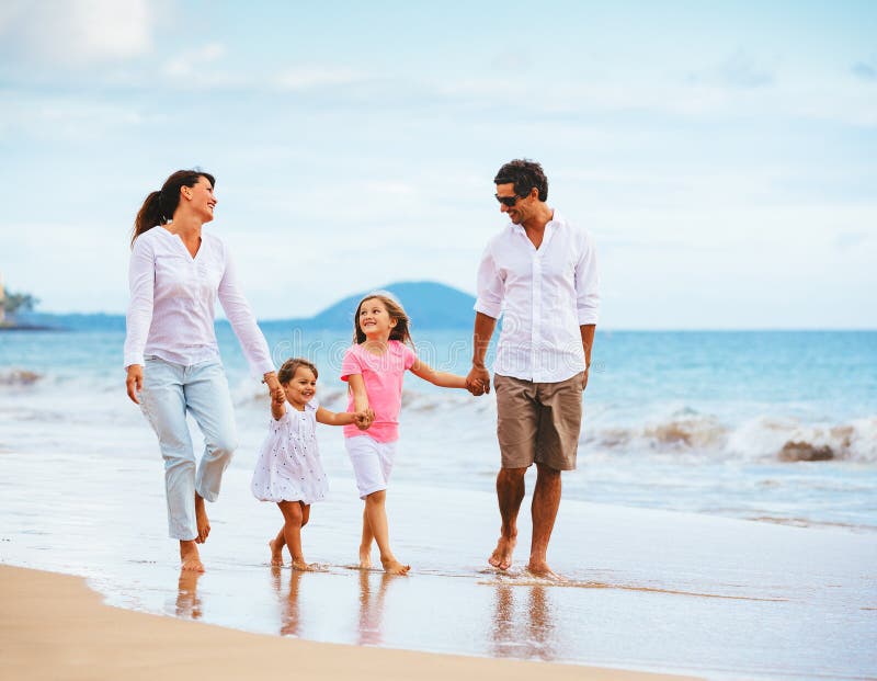 Happy young family walking on the beach