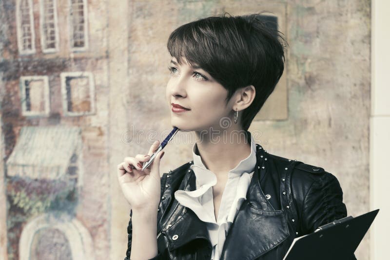 Happy young fashion business woman in leather jacket with clipboard stock image Happy young fashion business woman in leather jacket with clipboard stock image