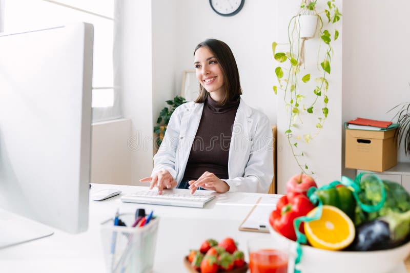 Happy young female dietitian doctor working at medical consultation stock images