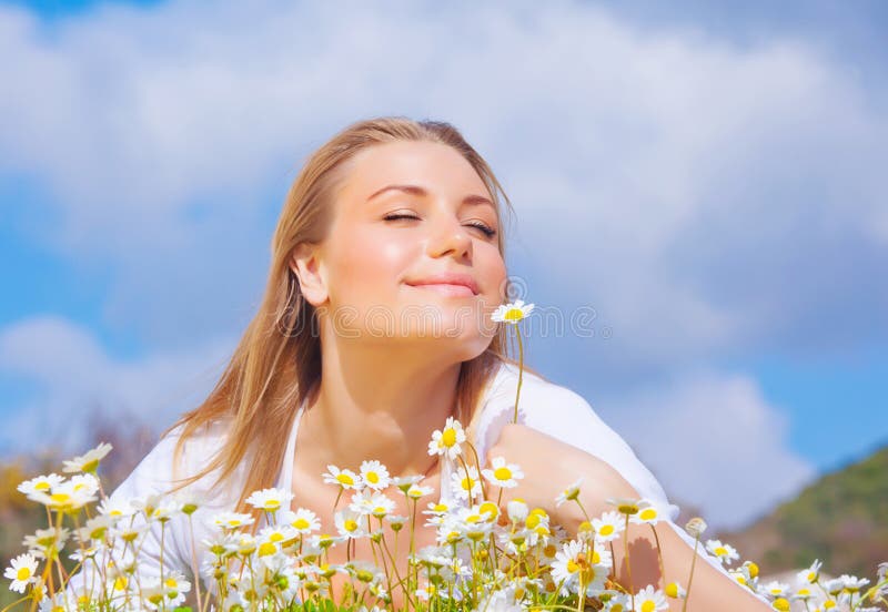 Beautiful woman enjoying daisy field and blue sky