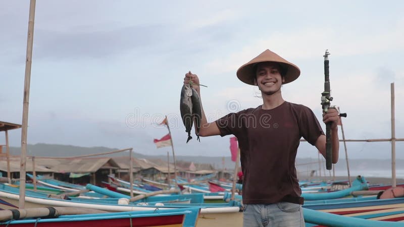 Happy young fisherman on the beach