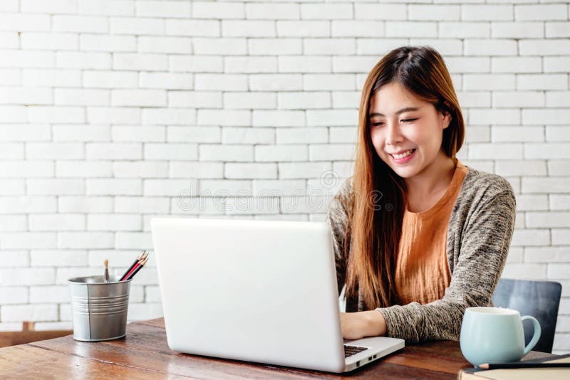 Happy Young Freelancer Woman Working on Computer Laptop in Cozy stock photo