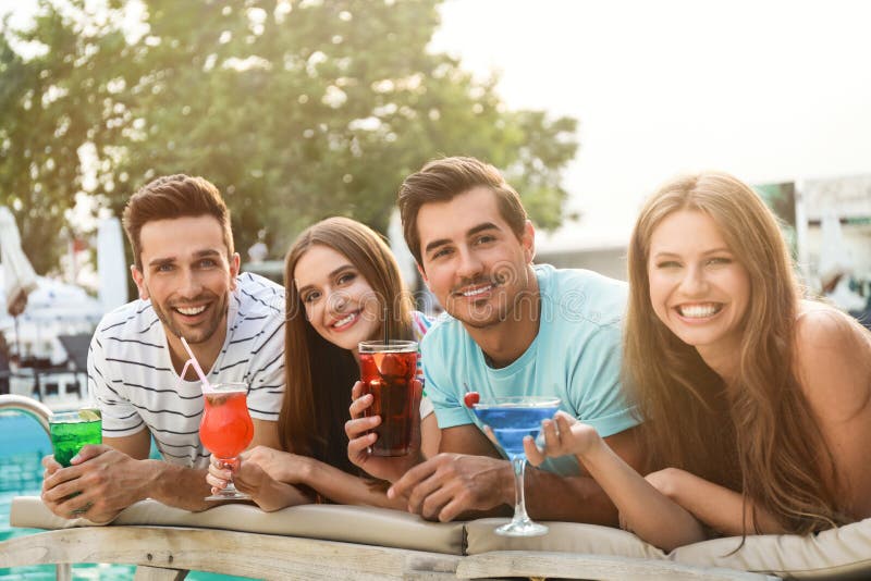 Happy young friends with fresh summer cocktails near swimming pool stock image Happy young friends with fresh summer cocktails near swimming pool stock image