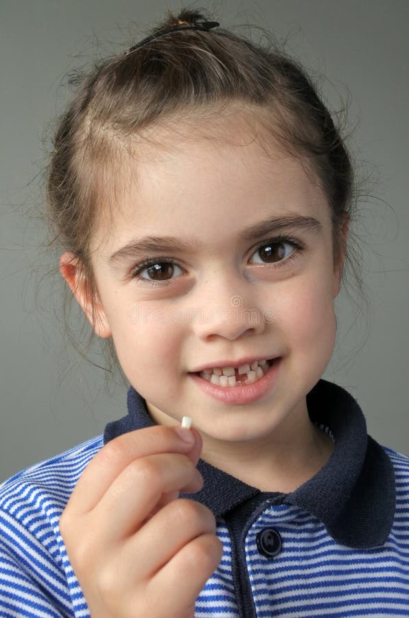 Happy Young Girl Holds Her First Falling Milk Teeth Stock Photo - Image