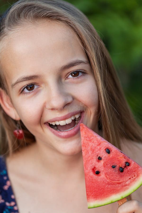 Happy young girl with a slice of watermelon on a stick stock images Happy young girl with a slice of watermelon on a stick stock images
