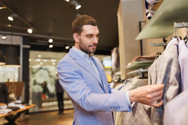 Happy Young Man Choosing Clothes in Clothing Store Stock Image - Image ...