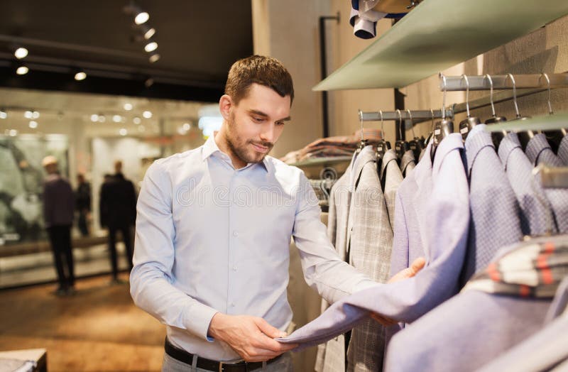 Happy Young Man Choosing Clothes in Clothing Store Stock Image - Image ...