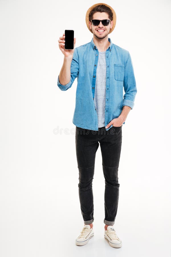 Happy young man standing and holding blank screen cell phone