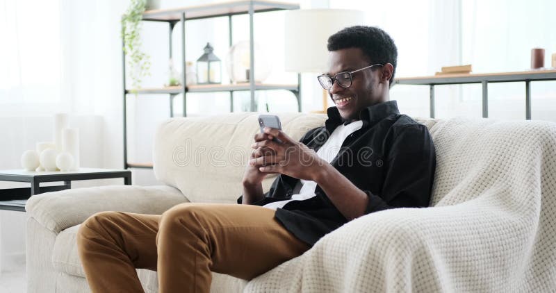 Happy young man text messaging using mobile phone stock footage