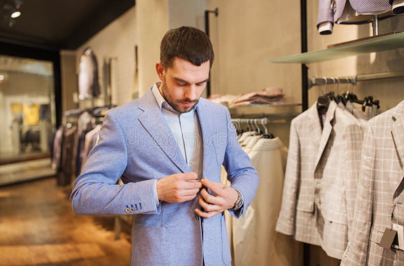 Happy Young Man Trying Jacket on in Clothing Store Stock Photo - Image ...