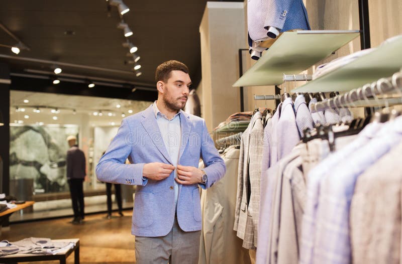 Happy Young Man Trying Jacket on in Clothing Store Stock Photo - Image ...