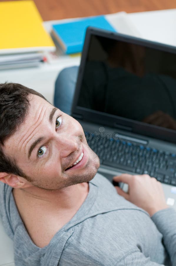 Happy young man working on laptop stock photos