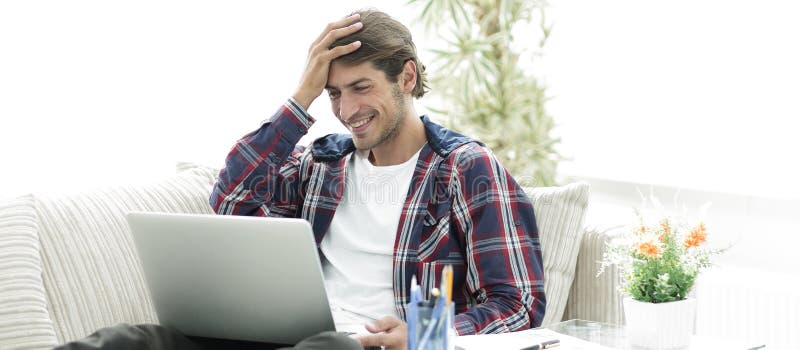Happy young man working with laptop from home. royalty free stock image Happy young man working with laptop from home. royalty free stock image