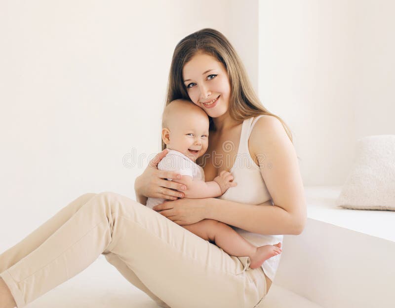 Happy young mother and baby together at home in whit royalty free stock image Happy young mother and baby together at home in whit royalty free stock image