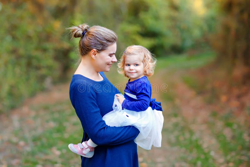 Happy young mother having fun cute toddler daughter, family portrait together. Woman with beautiful baby girl in nature royalty free stock image Happy young mother having fun cute toddler daughter, family portrait together. Woman with beautiful baby girl in nature royalty free stock image