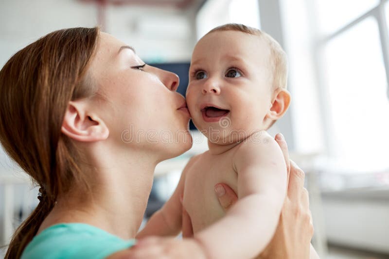 Happy young mother kissing little baby at home stock photo Happy young mother kissing little baby at home stock photo