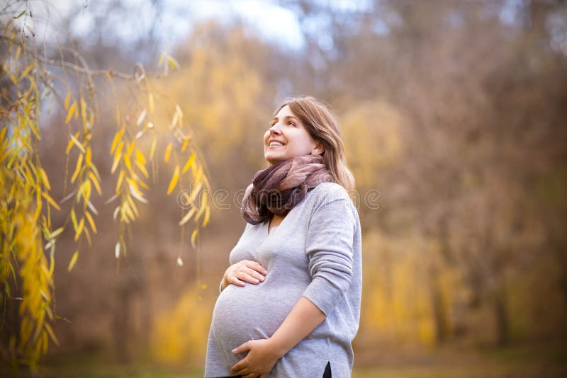 Happy young pregnant woman in autumn park royalty free stock image Happy young pregnant woman in autumn park royalty free stock image