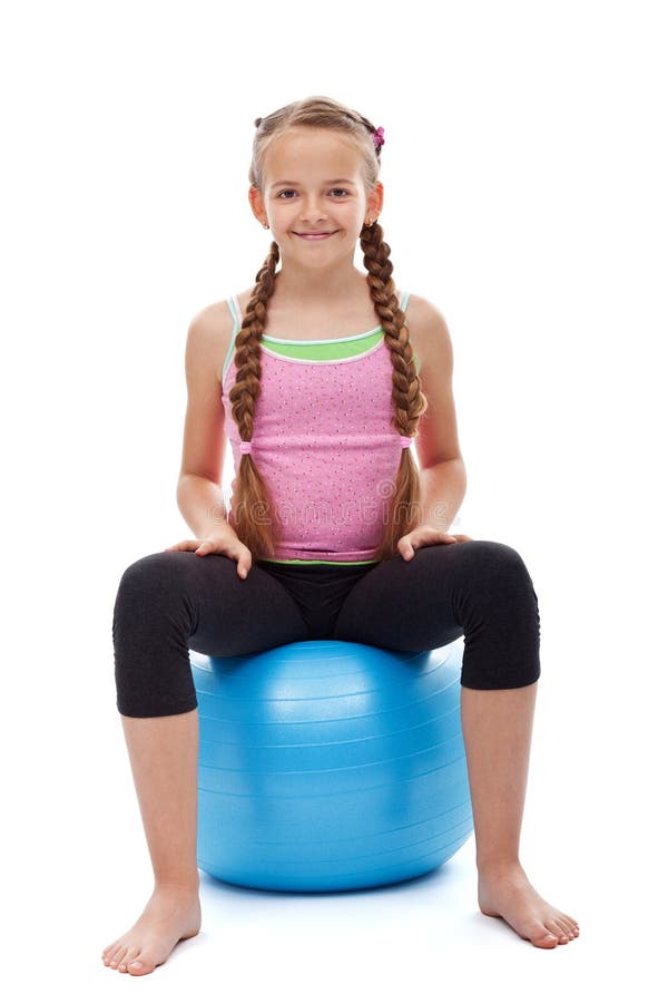 Happy young sporty girl sitting on large gymnastic rubber ball