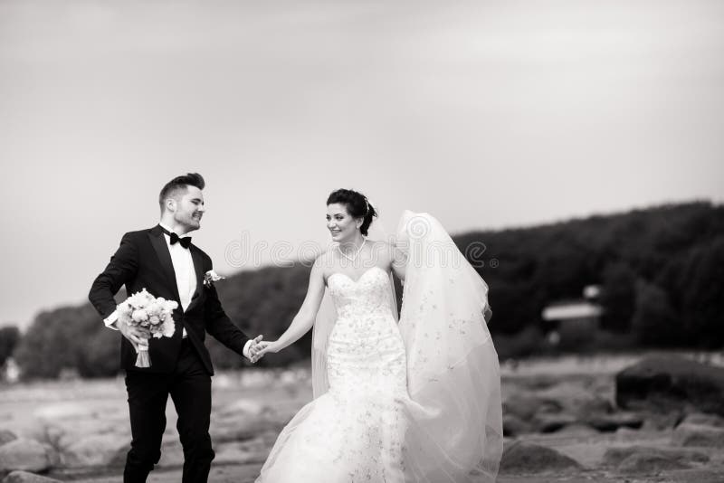Happy young wedding couple having fun on the beach. Black and white royalty free stock images Happy young wedding couple having fun on the beach. Black and white royalty free stock images