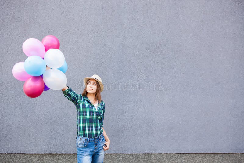 Happy girl with balloons near gray wall with copy space stock images Happy girl with balloons near gray wall with copy space stock images