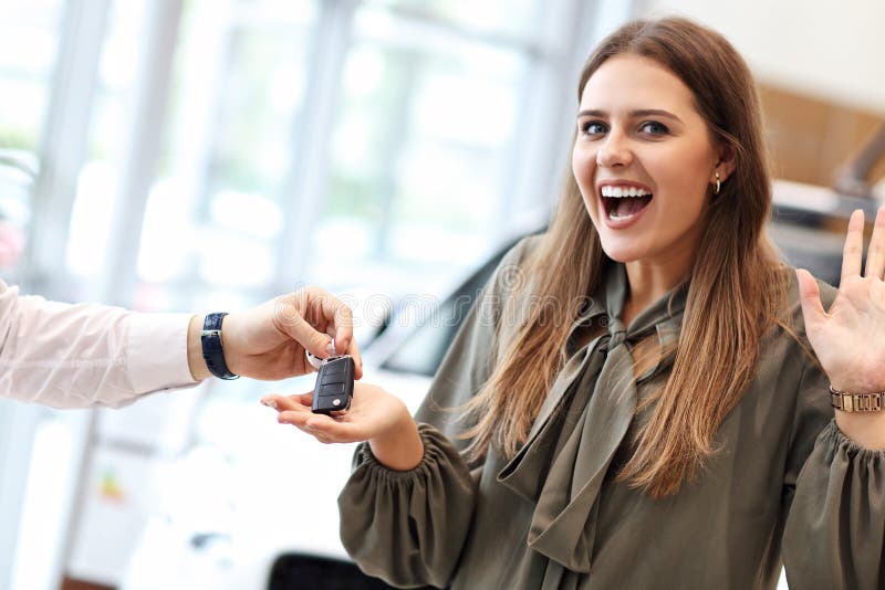 Happy Young Woman Buying Car in Showroom Stock Photo - Image of keys ...