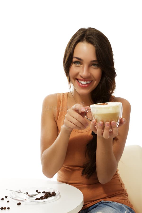 Happy young woman with a cappuccino coffee sitting royalty free stock photos