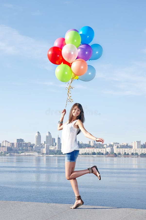 Happy young woman with colorful balloons