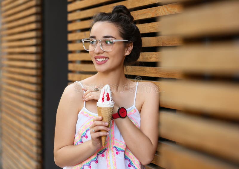 Happy young woman with delicious ice cream in waffle cone stock image Happy young woman with delicious ice cream in waffle cone stock image