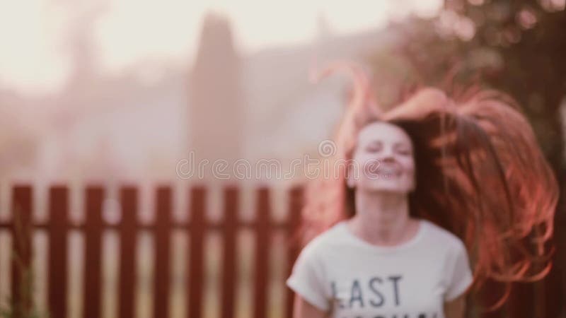 Happy young woman enjoying nature, turning, having fun, smiling, jumping of joy. Lady s hair flutters on wind.