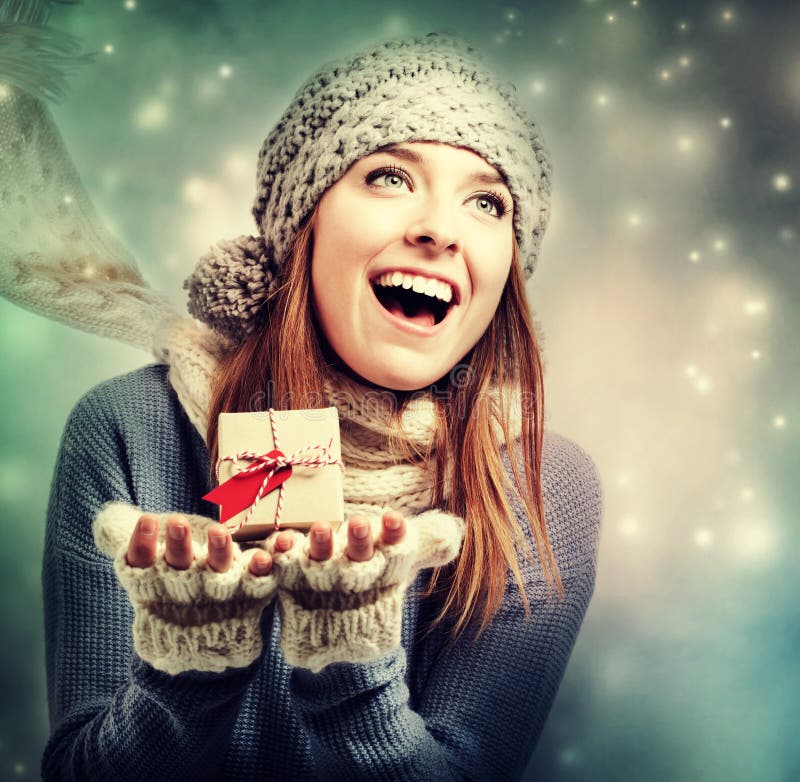 Happy young woman holding a small present box