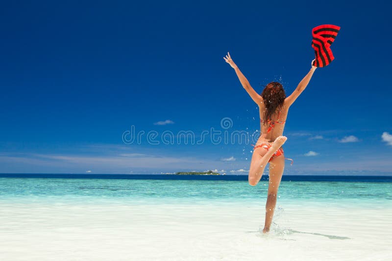 Happy young woman jumping on the beach. Happy lifestyle