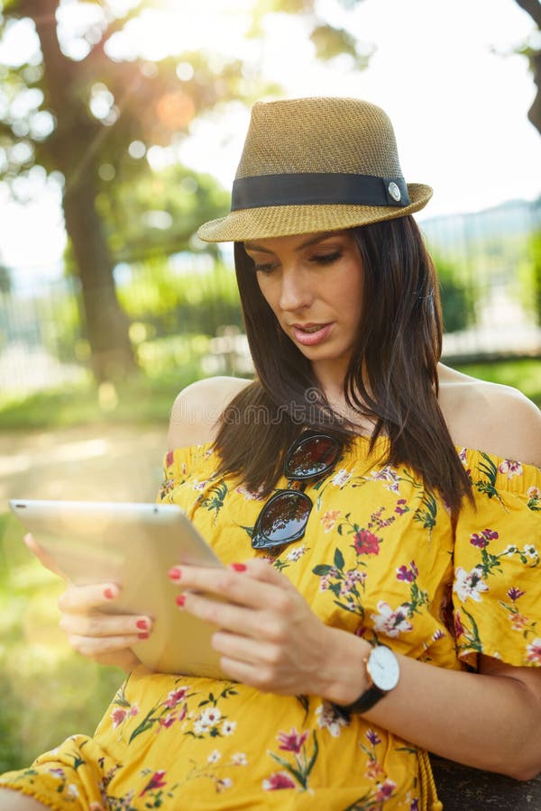 Happy young woman outdoor in summer using tablet royalty free stock photo Happy young woman outdoor in summer using tablet royalty free stock photo