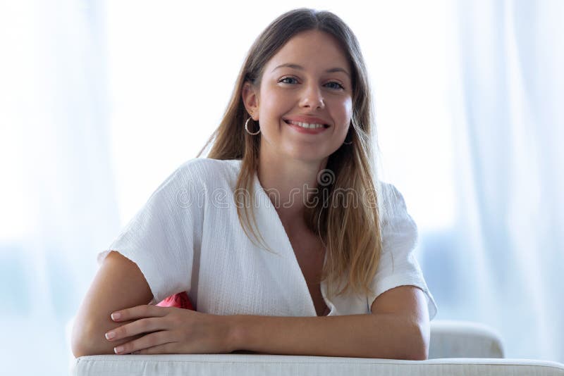 Happy young woman with perfect smile looking at camera at home