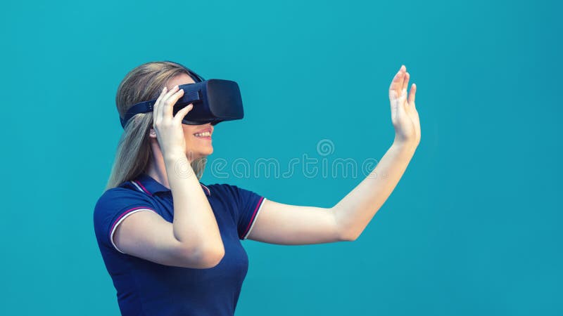 Happy young woman playing on VR glasses indoor. Virtual reality concept with young girl having fun with headset goggles