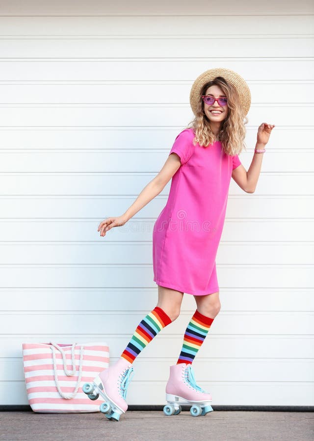 Happy young woman with retro roller skates near garage door. Happy young woman with retro roller skates near white garage door royalty free stock photography Happy young woman with retro roller skates near garage door. Happy young woman with retro roller skates near white garage door royalty free stock photography