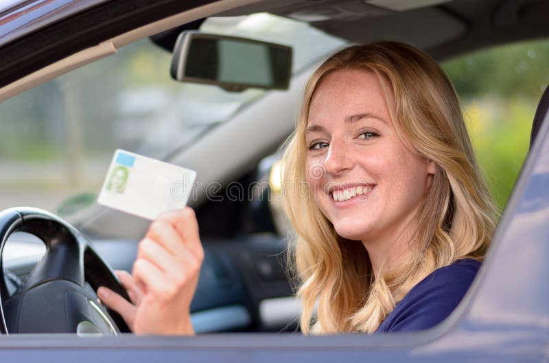 Happy young woman showing off her drivers license stock photography Happy young woman showing off her drivers license stock photography