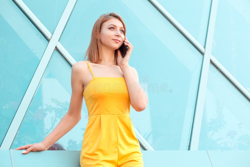Happy young woman smiling and talking on a smartphone near Louvre royalty free stock photography Happy young woman smiling and talking on a smartphone near Louvre royalty free stock photography