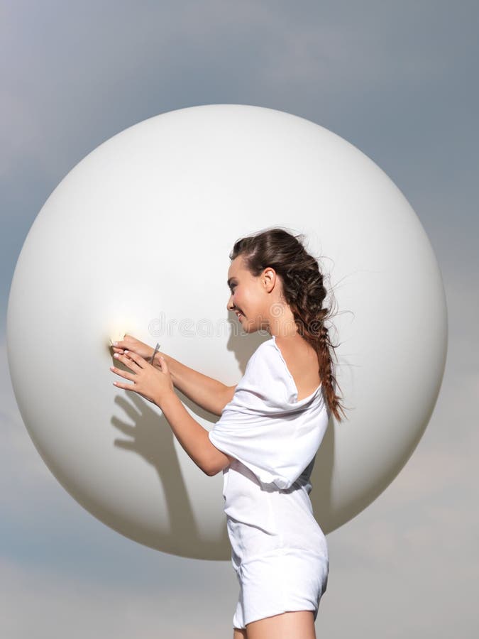 Happy young woman standing with white balloon stock photo