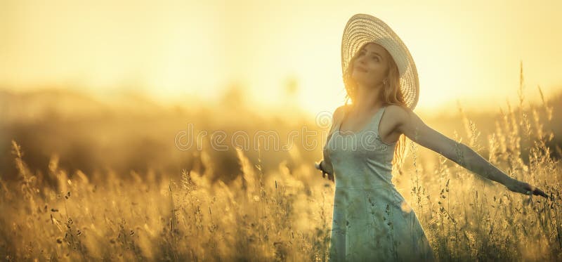 Happy young woman on the sunset or sunrise in summer nature with open hands