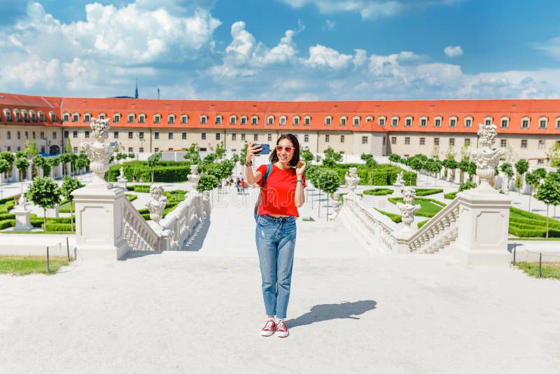 Mladá žena turistické procházky a obdivovat pohled na typické, ale nádherné květinové zahrady v barokním stylu v Evropě na slunné