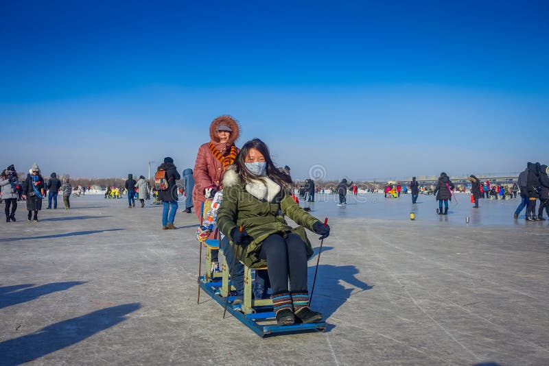 Harbin, China - 9. Februar 2017: Freunde auf einem Schlitten, der Spaß auf gefrorenem Fluss Songhua während der Winterzeit hat stockfotografie Harbin, China - 9. Februar 2017: Freunde auf einem Schlitten, der Spaß auf gefrorenem Fluss Songhua während der Winterzeit hat stockfotografie