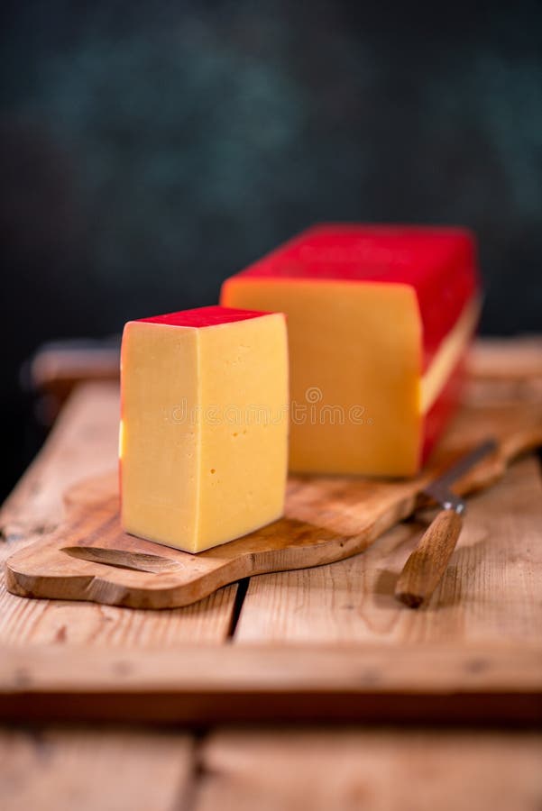 Hard Cheese Parmesan on Wooden Board on Sunlight Table Traditional