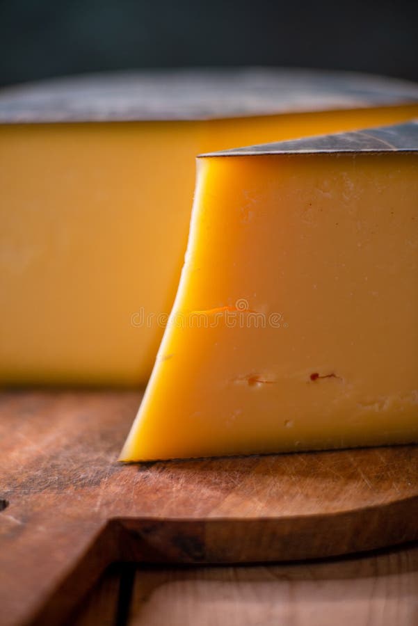 Hard Cheese Parmesan on Wooden Board on Sunlight Table Traditional