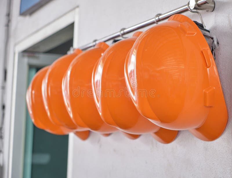 Hard Hats Hanging on Hook Against the Dirty White Wall. Stock Image - Image  of background, helmet: 169252977