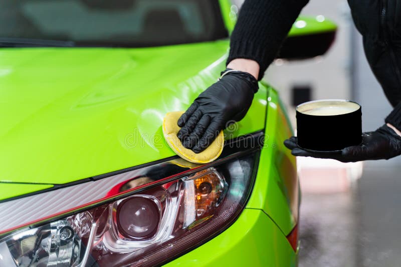 Hard wax for protection paintwork of car using sponge for remove paint scratches. Applying hard wax with a yellow sponge