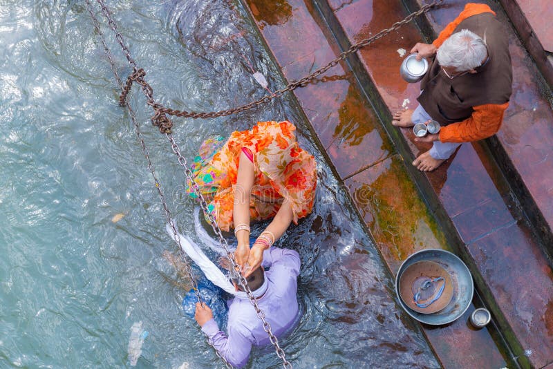 Haridwar, India - 11 marzo 2017: gente non identificata che bagna e che prende le abluzioni nel Gange ai ghats santi in Haridw fotografia stock libera da diritti Haridwar, India - 11 marzo 2017: gente non identificata che bagna e che prende le abluzioni nel Gange ai ghats santi in Haridw fotografia stock libera da diritti