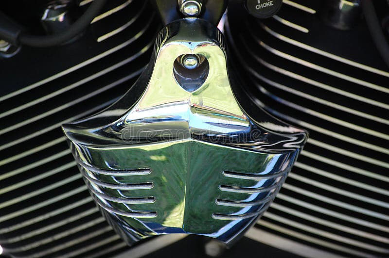 Close up of a harley davidson chrome air cleaner with matt blackpots and silver cooling fin edges. Close up of a harley davidson chrome air cleaner with matt blackpots and silver cooling fin edges