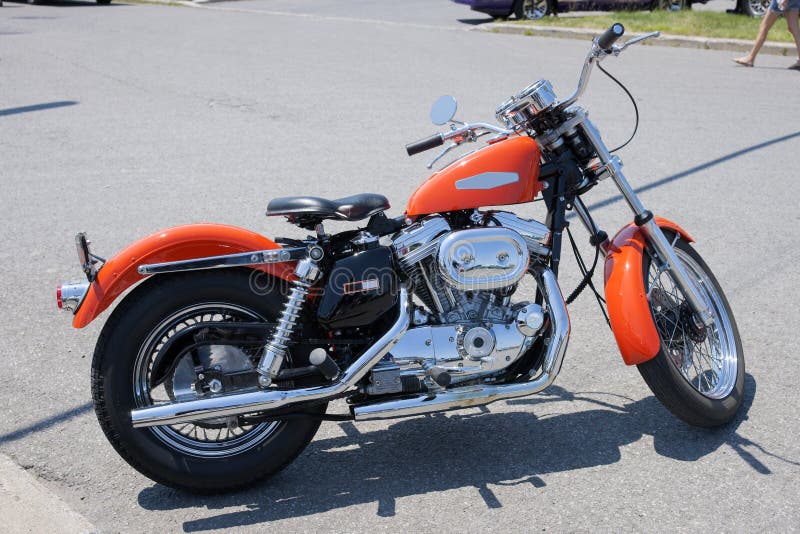 Picture of orange harley davidson motorbike parked in the street