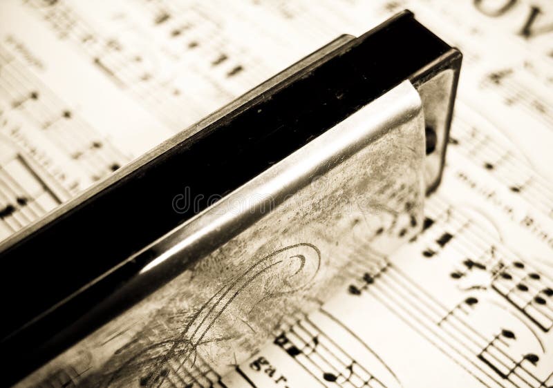 Old harmonica on sheet music ( retro inspired image )